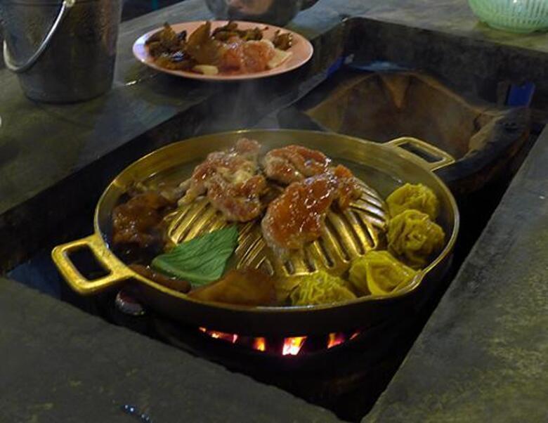 В каждый стол встроена печь, на которой можно готовить хоть жареное мясо, хоть отварные пельмешки.